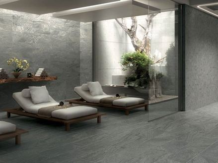 Spabereich mit grauem Feinsteinzeug und zwei Liegen