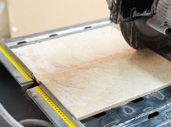 Eine Säge schneidet hellen Naturstein