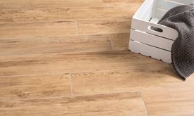 Weiße Kiste auf Fußboden mit Feinsteinzeugfliesen in Holzoptik