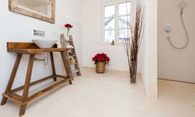 Modernes Badezimmer mit Holzmöbeln und hellen Kalksteinfliesen