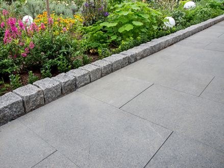 Weg mit Granitplatte Padang Dunkel und angrenzendes Blumenbeet