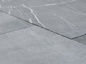 Platten aus Kalkstein Blaustein Azur in der Nahaufnahme, in dem hellen Grauton des Natursteins sind weiße Maserungen sichtbar