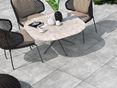 Terrasse mit Stuhl und Sesseln, als Bodenbelag helle Platten aus Feinsteinzeug in Betonoptik