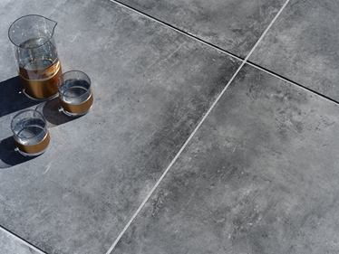 Dunke Betonoptik Terrassenplatte Vulkano mit Karaffe und Gläsern