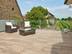 Terrasse mit Holzoptik-Platten und einem Weinberg im Hintergrund