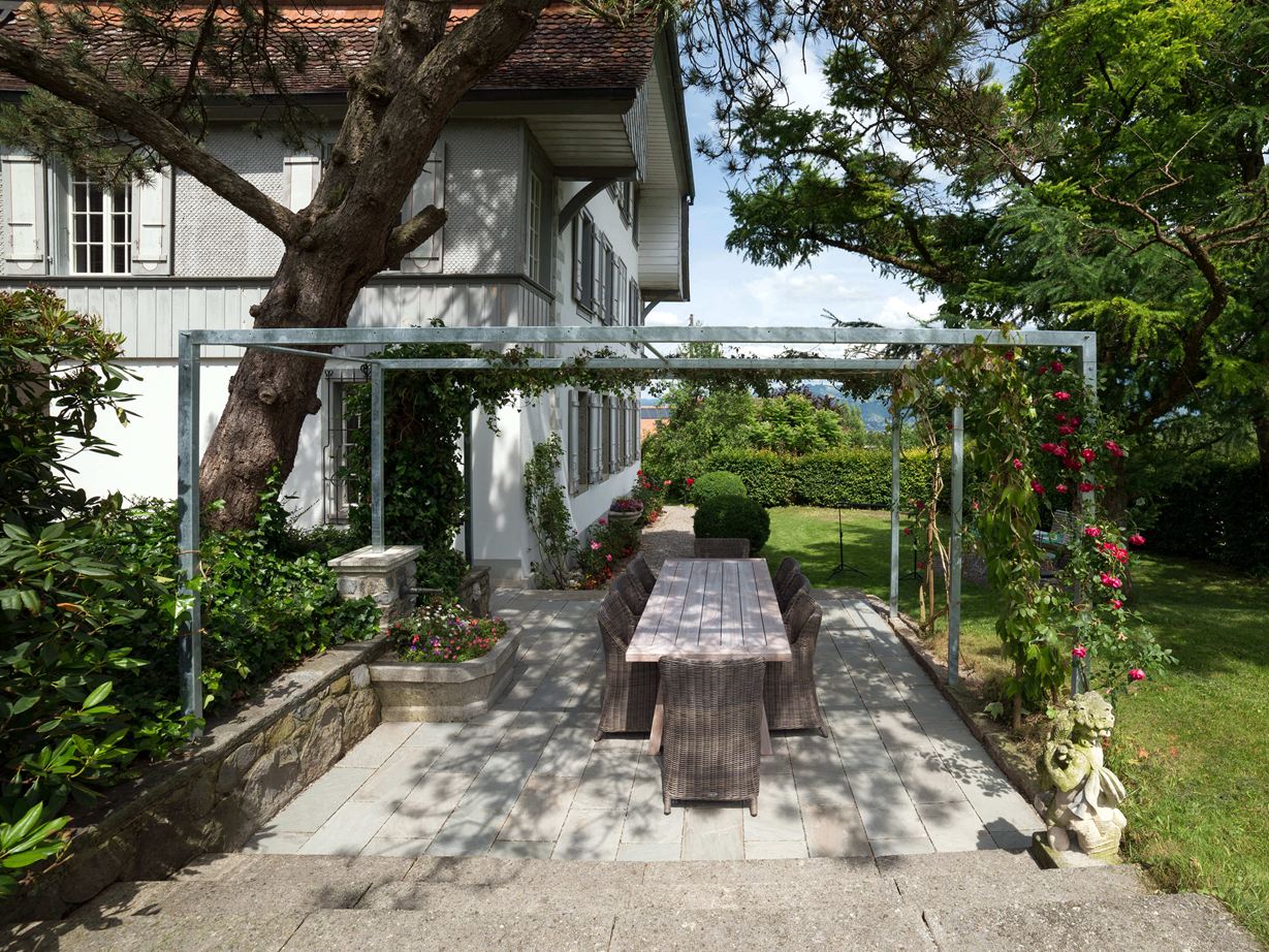 Ein wunderschöner Naturstein für die Terrasse! Terrasse mit Natursteinplatten aus grauem Sandstein in natürlichem Garten