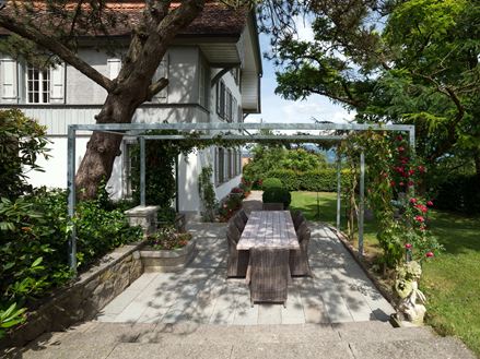 Terrasse mit Natursteinplatten aus grauem Sandstein in natürlichem Garten