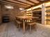 Weinkeller mit rustikalen Holzmöbeln, Weinregalen und grauen Sandsteinplatten als Bodenbelag
