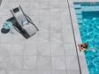 Terrasse mit hellgrauen Platten in Schieferoptik und Mädchen im Pool von oben.