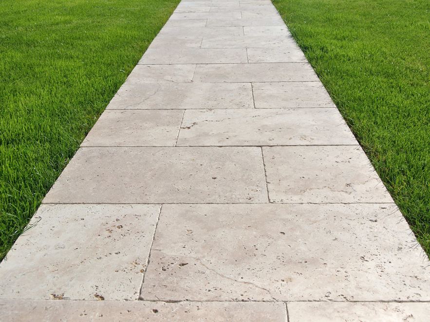 Gehweg aus Travertinplatten auf Rasen