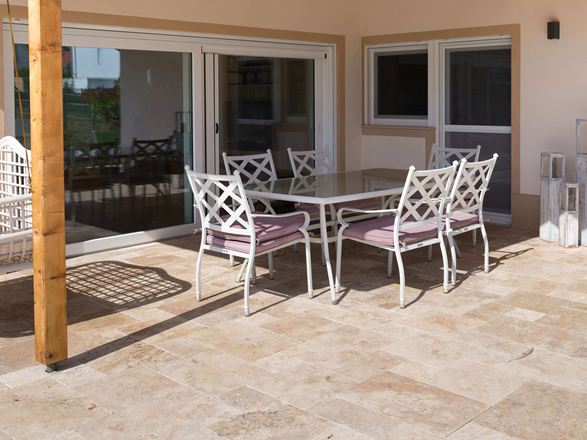 Travertinterrasse mit weißen Möbeln