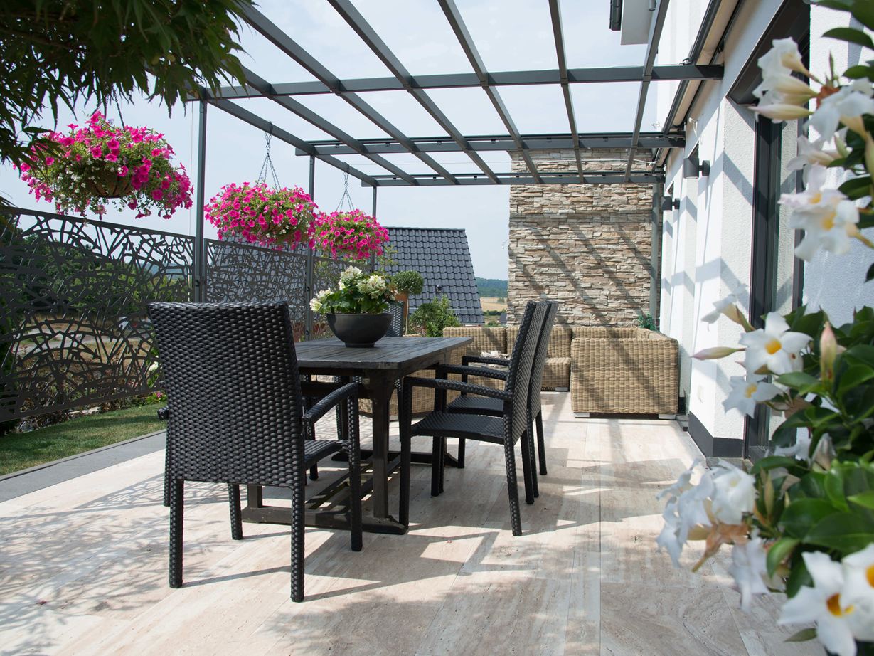 Ein natürliches Flair für eine moderne Terrasse! Terrasse mit dunklen Gartenmöbeln und holzähnlichem Travertin Natura als Bodenbelag