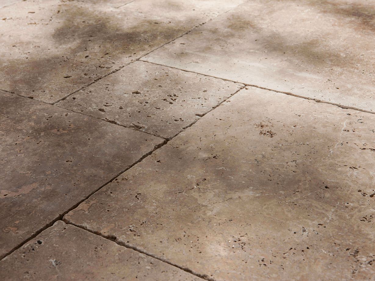 Rustikal und naturnah mit vielen Poren Travertin-Platten Noce, getrommelt, seitliche Nahaufnahme mit Halbschatten