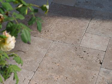 Die Spätnachmittagssonne spielt auf dem Terrassenboden, von rechts ragen Zweige ins Bild