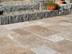 Terrasse mit Natursteinplatten aus braunem Travertin, im Hintergrund eine Treppe mit Granitsteinen