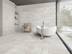 Badezimmer mit Badewanne und hellen Betonoptik-Fliesen Concrete Stone