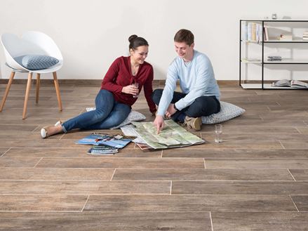 Paar sitzt auf Feinsteinboden Indie Nova und schaut sich eine Karte an