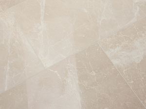 Die zarten Wolkenmuster in der Oberfläche machen jede Marmorfliese zu einem Unikat Verlegte Marmorfliese Burdur Cream mit polierter Oberfläche und weißen Maserungen in der beigefarbenen Grundfläche