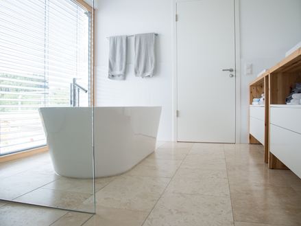 Modernes Bad mit Travertin Classic Light und freistehender Badewanne