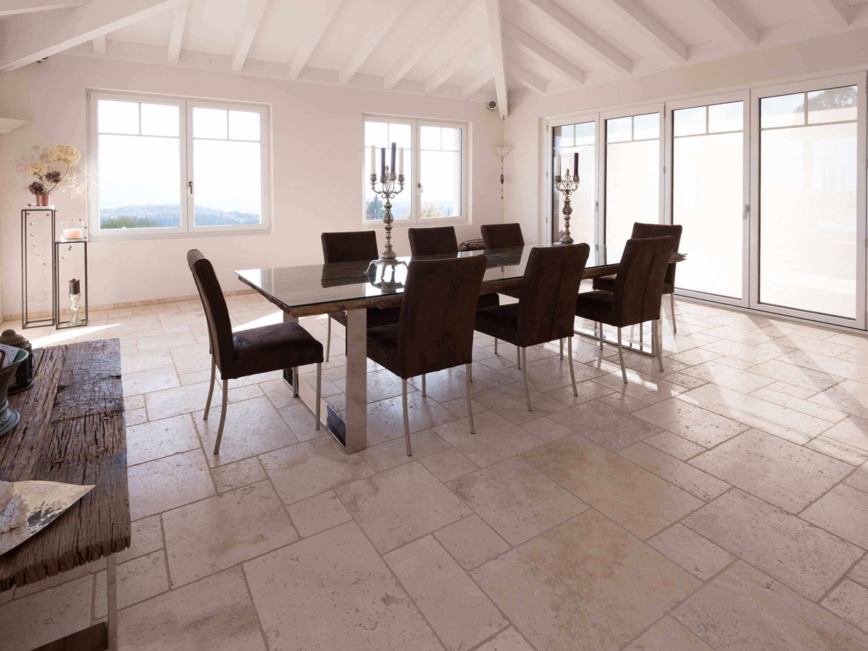 Travertin Light: helle und freundliche Wirkung Esszimmer mit hoher Decke, Tisch und Stühlen auf Travertin Light in römischem Verband