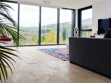 Wohnzimmer mit Travertinfliesen Medium Line und großer Fensterfront