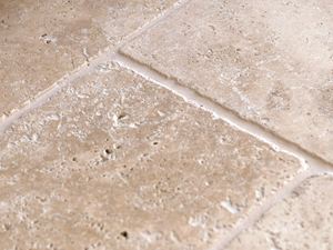 Fußschmeichler mit getrommelter Oberfläche Detailaufnahme des Travertin Medium in Beige