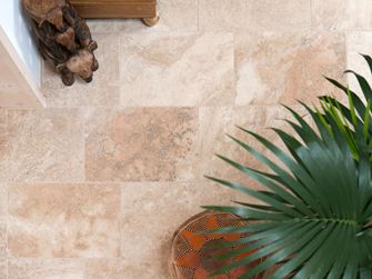 Aufnahme von verlegtem Travertin Fliese Rustic mit Pflanzen und Holzaccessoires aus der Vogelperspektive