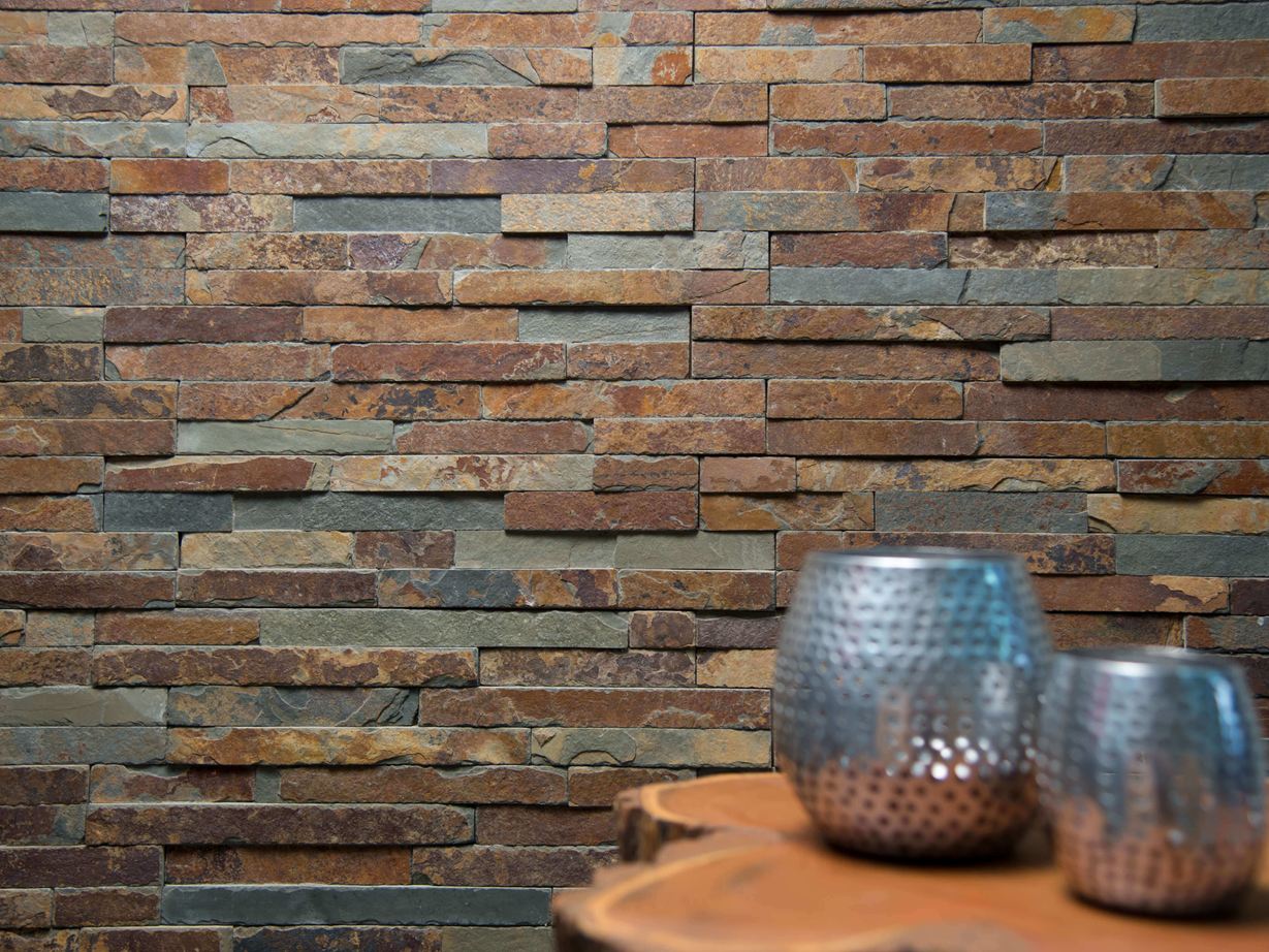 Hingucker: Farbenspiel an der Wand Zwei Vasen auf einem Holztisch vor Wandverblender aus Naturschiefer in bunten Farbnuancen