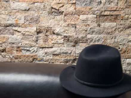 Schwarzer Hut vor Wandverblender Scabas