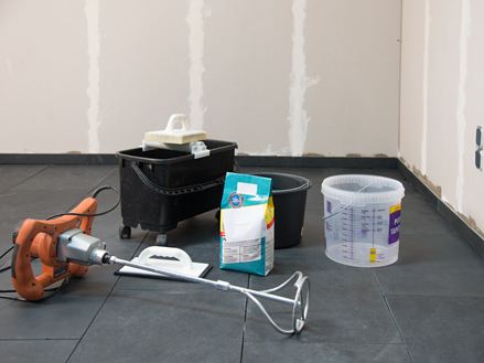 Werkzeuge und Material für die Verlegung von Natursteinfliesen