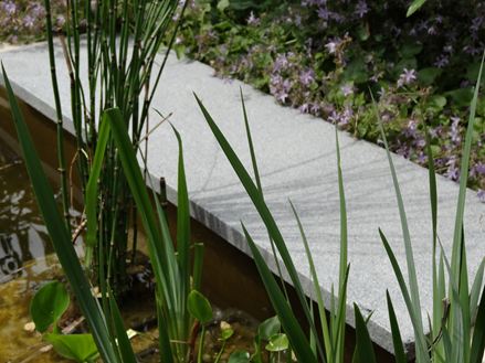Universalplatte als Teichumrandung mit Gräsern im Vordergrund