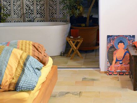 Schlafzimmer mit bunten Kissen und Solnhofer Kalkstein als Bodenbelag