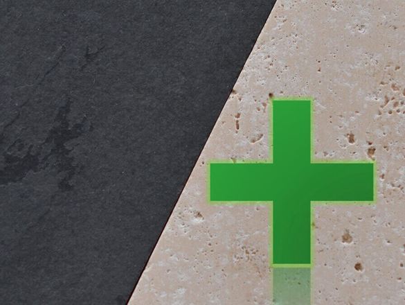 Heller Naturstein neben dunklem Naturstein, darauf ein grünes Kreuz