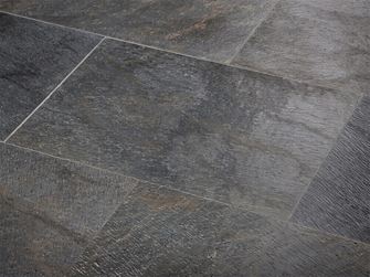 Nahaufnahme von verlegten Natursteinfliesen in dunklem Anthrazit mit bunten Farbnuancen