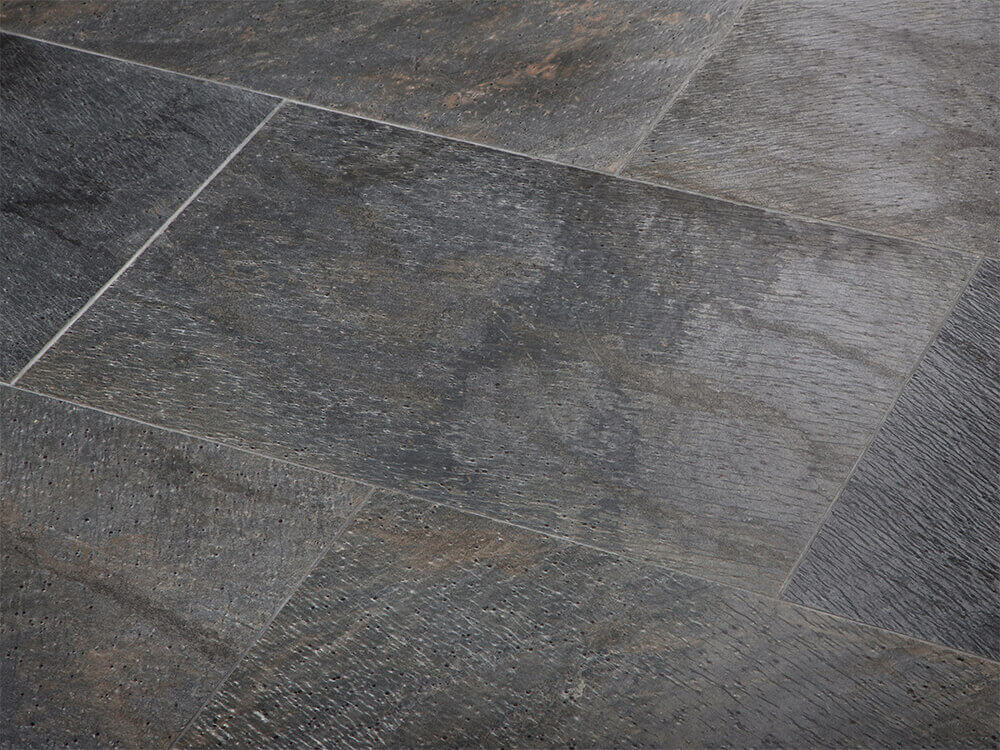 Nahaufnahme von verlegten Natursteinfliesen in dunklem Anthrazit mit bunten Farbnuancen