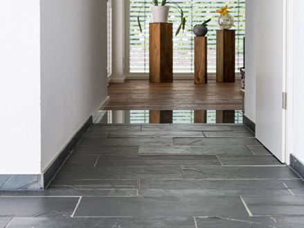 Gang mit Naturschiefer Black Rustic und Holzdielen im Hintergrund