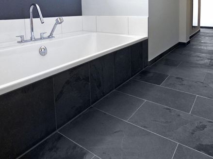 Bildausschnitt Badewanne im Bad mit dunklem Schiefer Mustang Bodenbelag