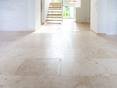 Große Fläche mit hellen Travertinfliesen Classic Light, im Hintergrund eine freie Holztreppe