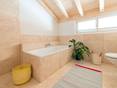 Bad mit vollverkleideter Badewanne und Travertinfliese Light als Bodenbelag