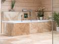 Badewanne mit Travertinfliese Rustic verkleidet und Holzwand im Hintergrund
