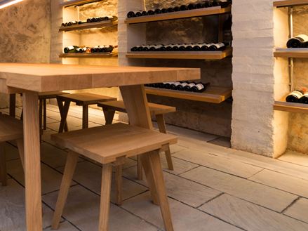 Weinkeller mit Holzmöbeln, Weinregalen und Sandstein Kandla Grey als Bodenplatten