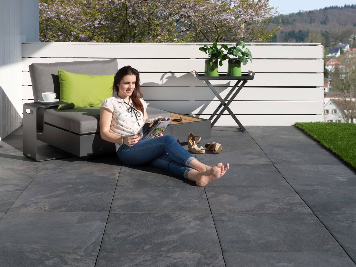 Junge Frau liest auf Alpine Black-Terrasse