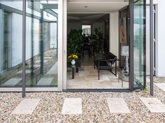 Blick von Travertin Rustic Terrasse in den stilvollen Wintergarten