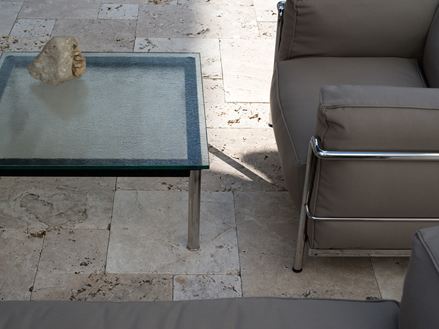 Schattenspiele an moderner Sitzgruppe auf schönem Travertin