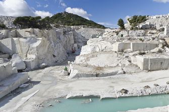 Steinbruch in der Sonne, davor ein See