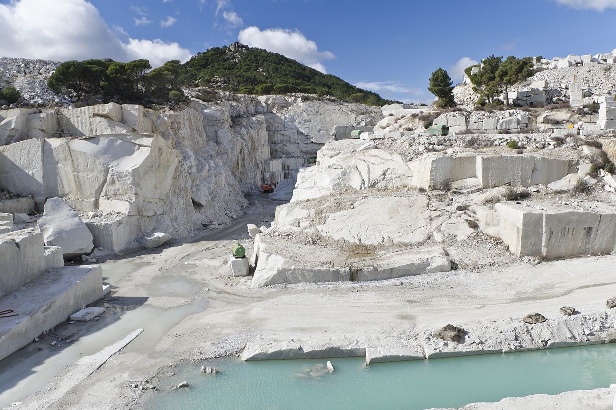 Steinbruch in der Sonne, davor ein See