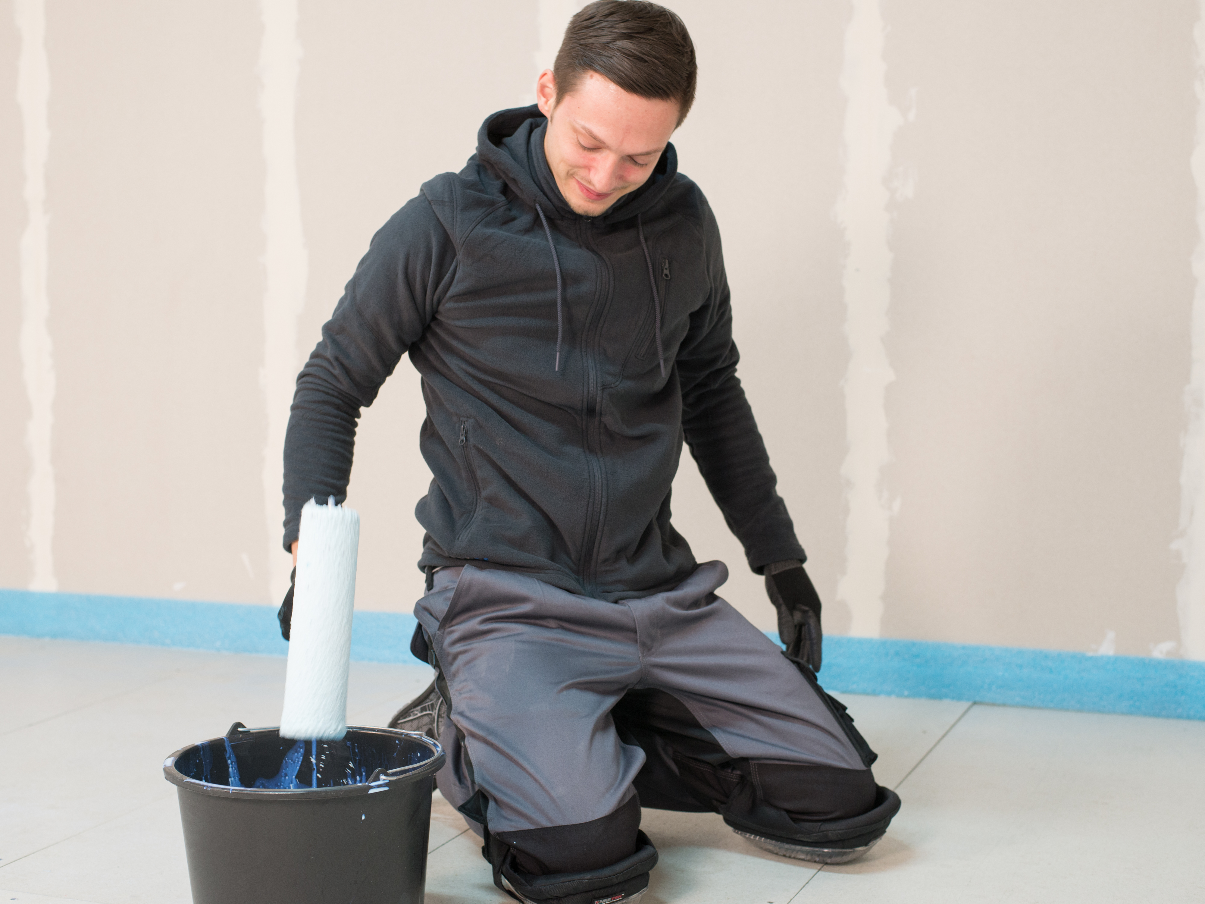 Fliesenleger grundiert den Boden