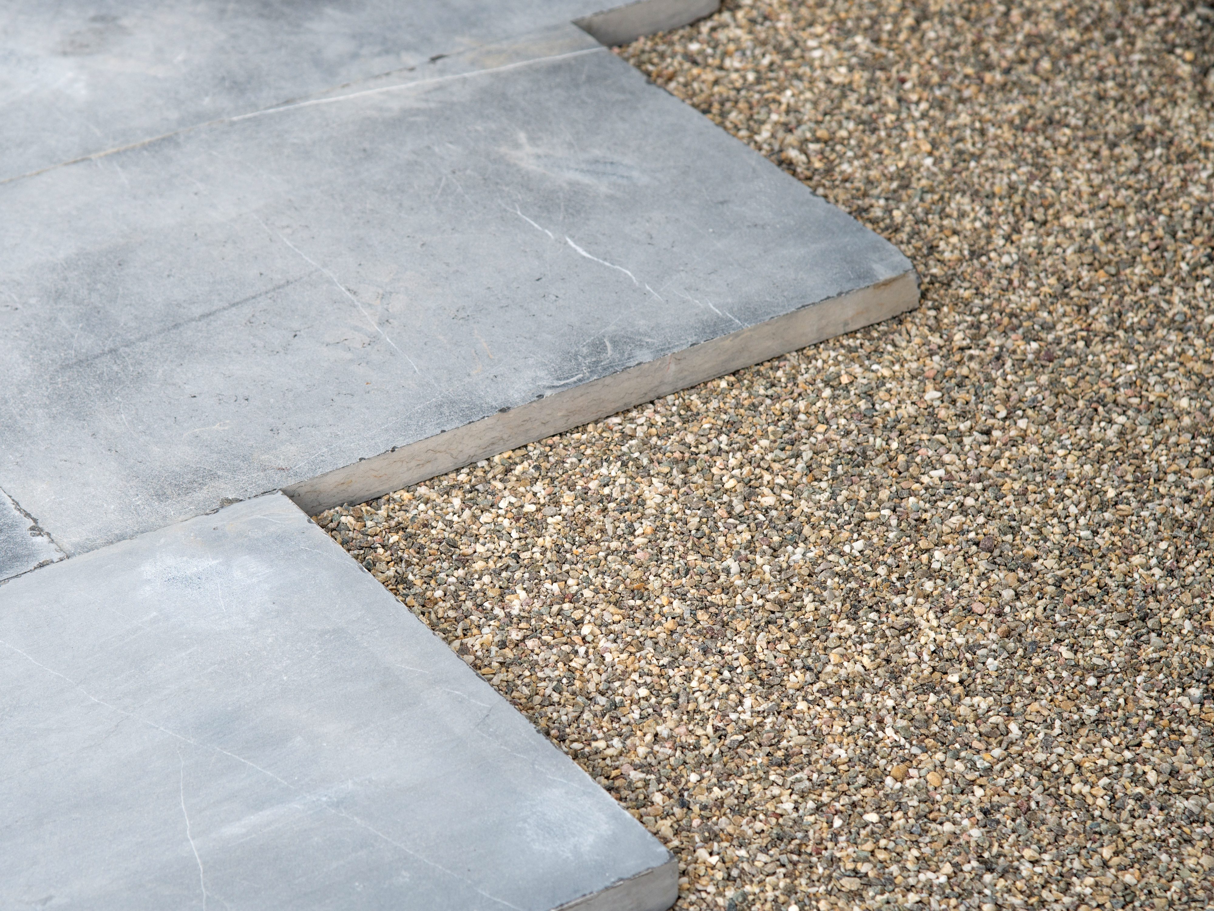 Blau-graue Kalksteinplatten in einem Edelsplittbett