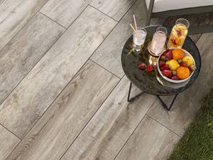 Rustikal: Das Dielenformat der Terrassenplatten Tisch mit Früchten auf Holzoptikplatten Indie Smoke
