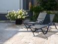 Terrassenfreuden mit dem Travertin Rustic Zwei Liegestühle und Blumenstock auf getrommelter Travertinplatte Rustic